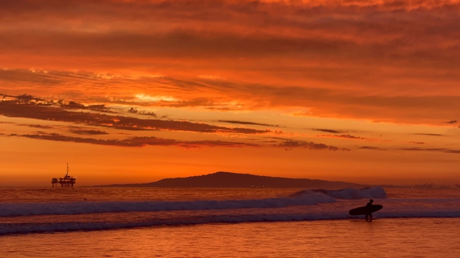 Surfer at sunset on the California coast